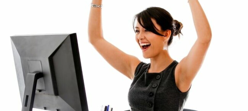 Woman looks immensely happy while staring into blank screen of unplugged monitor
