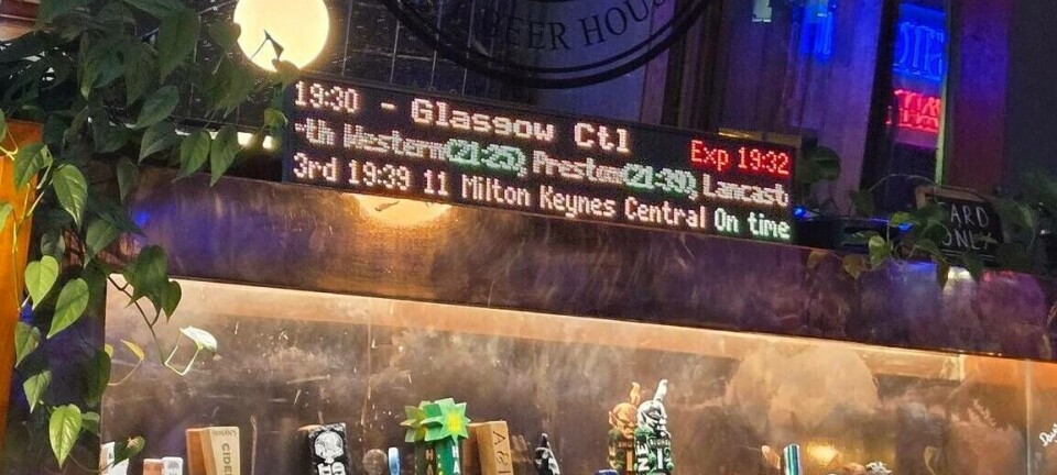 Departure board showing train times behind a bar