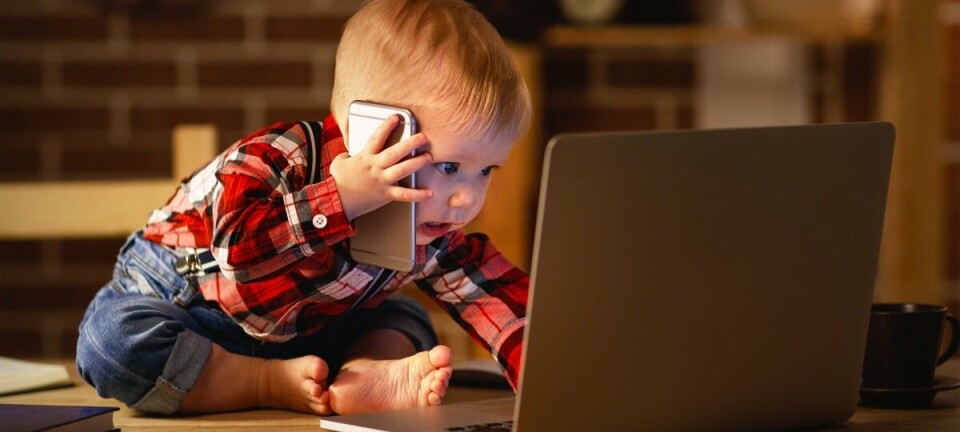 Toddler working with computer and smartphone