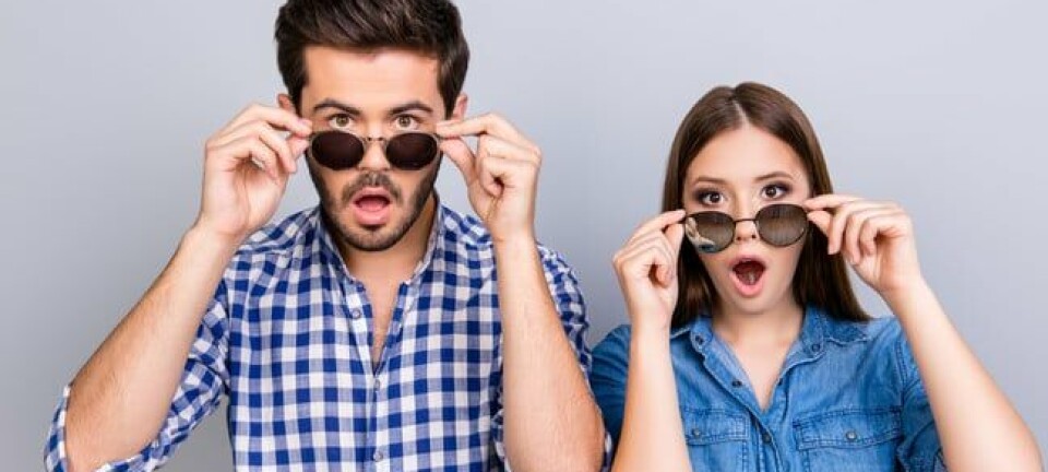 Couple wearing sunglasses looking surprised by something