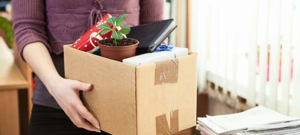 Woman packs up contents of desk. Image via shutterstock