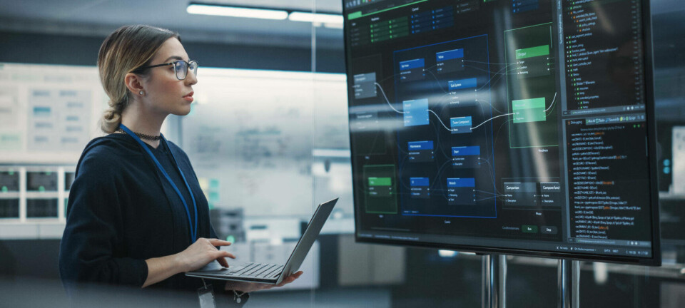 A QA engineer works through a project on a large screen in an office