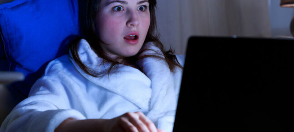 Woman in bathrobe is shocked by something she is reading on her laptop. Pic via Shutterstock