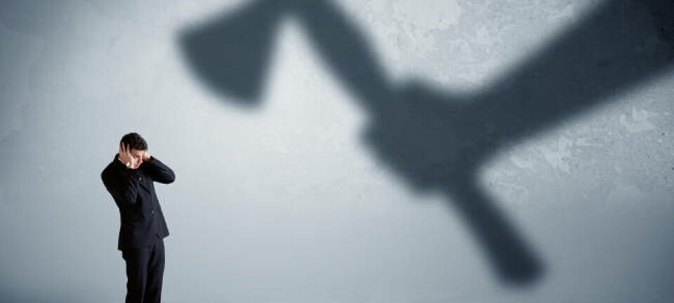 A hand holding an axe in shadow