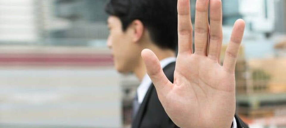 man holds hand up in gesture of rejection