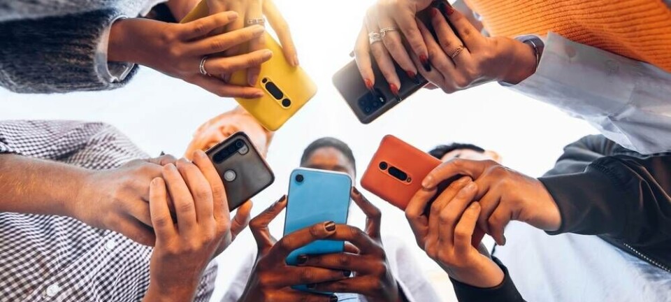 Teens standing in a circle looking at their phones