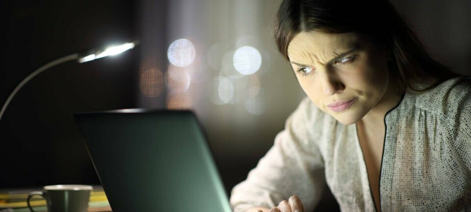 woman squints suspiciously at laptop