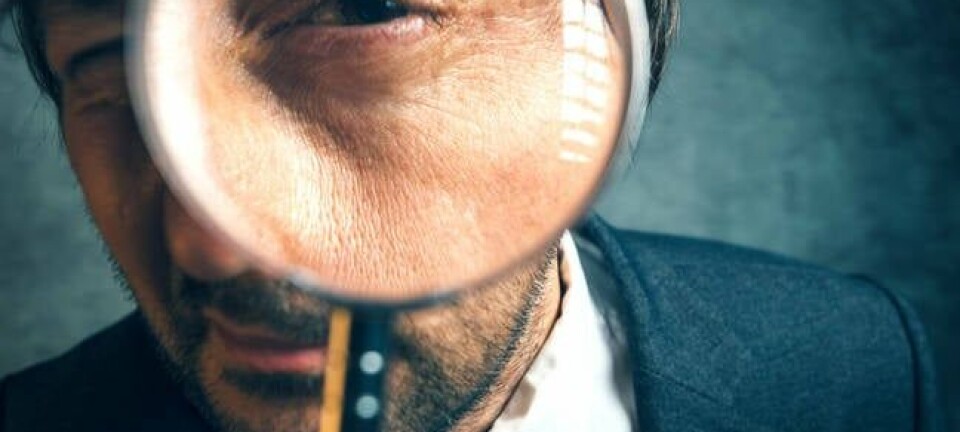 man holds magnifying glass