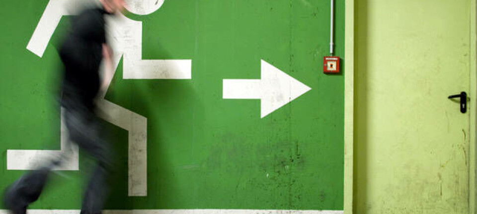 Man runs to fire exit in a corridor