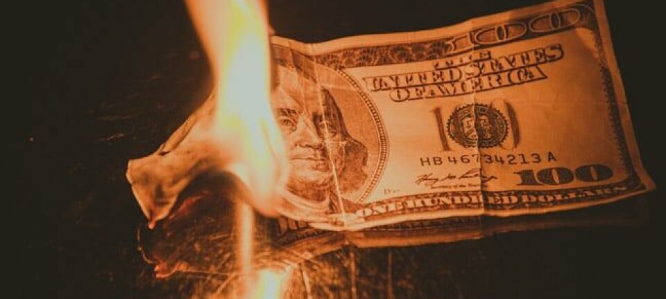 Burning money, photo via Shutterstock