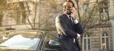 guy in suit talks on phone outside office