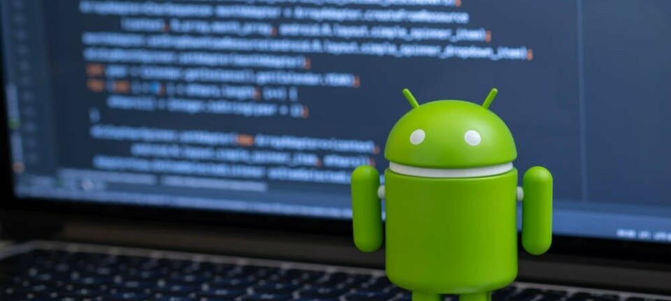 Google Android toy in front of a laptop showing some code