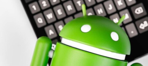 android reclines on a keyboard on smartphone