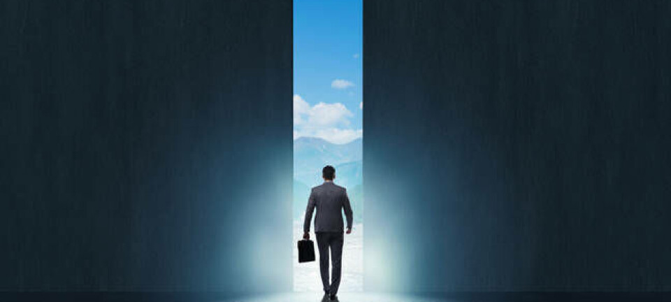 Business suit wearing man walks out of closing door in darkened room into the bright sunlight and blue sky