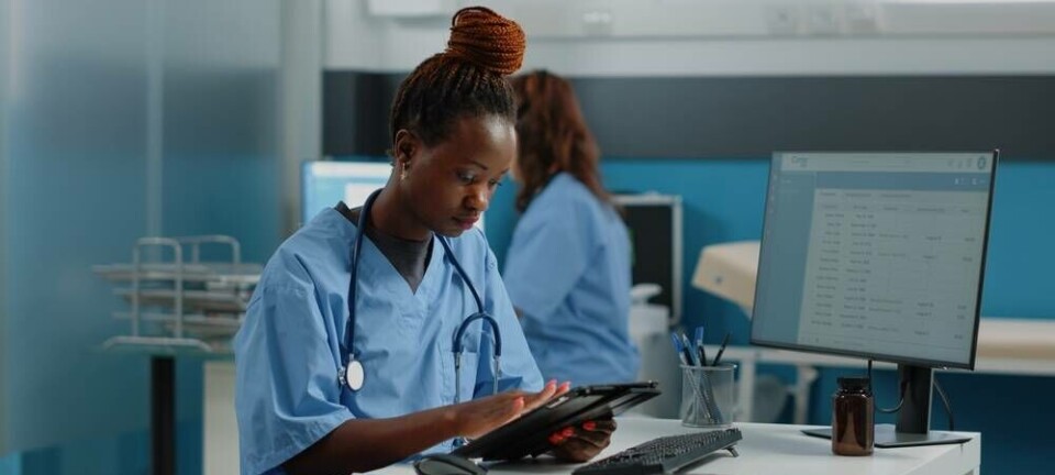 woman wearing nurse's scrubs w tablet
