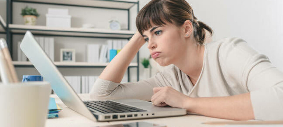 Tired disappointed woman working at office desk with a laptop