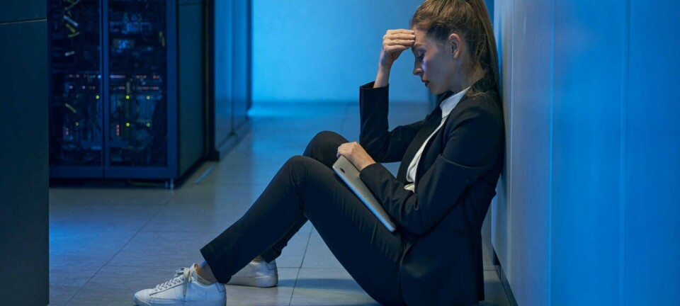 A datacenter worker sitting down looking dejected