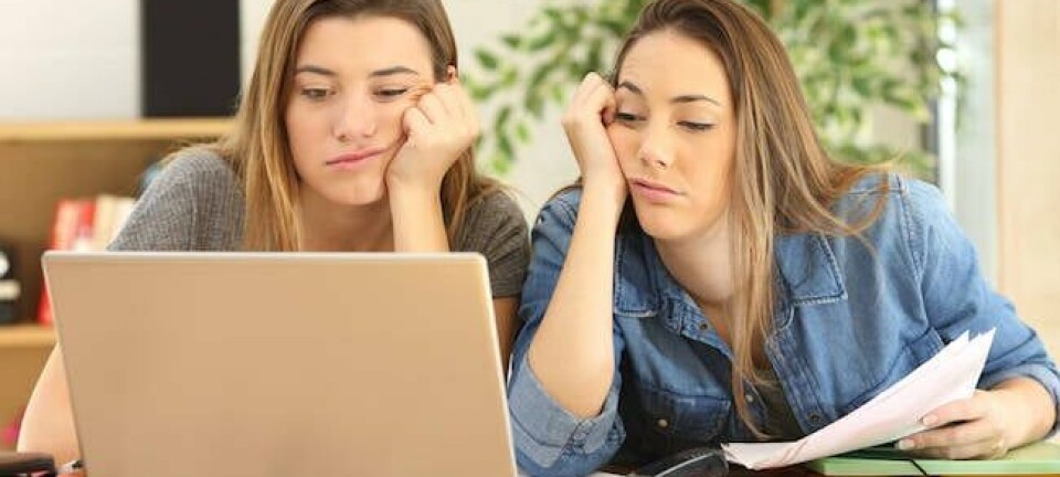 fed up uni students looking at failing laptop