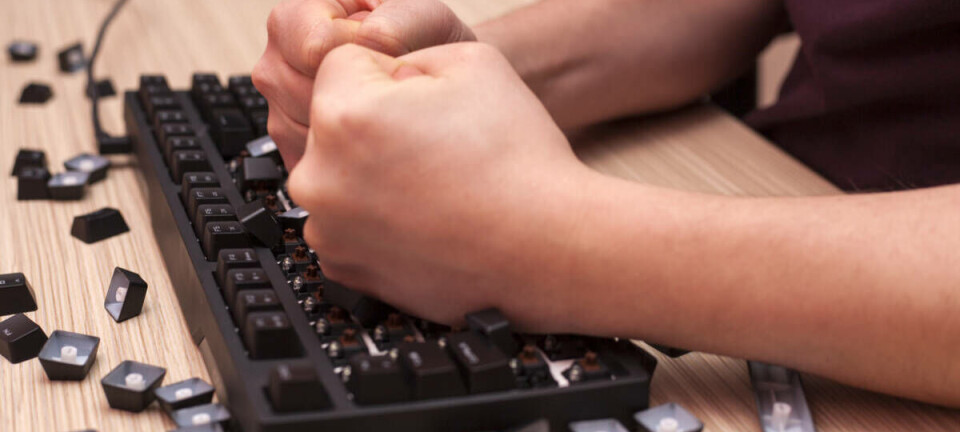 Someone smashing keys off a computer keyboard with their fists