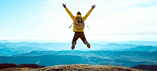 Someone jumping for joy on top of a mountain
