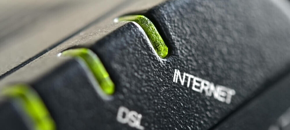 Close up of a generic black broadband router showing green LEDs for internet and DSL connectivity