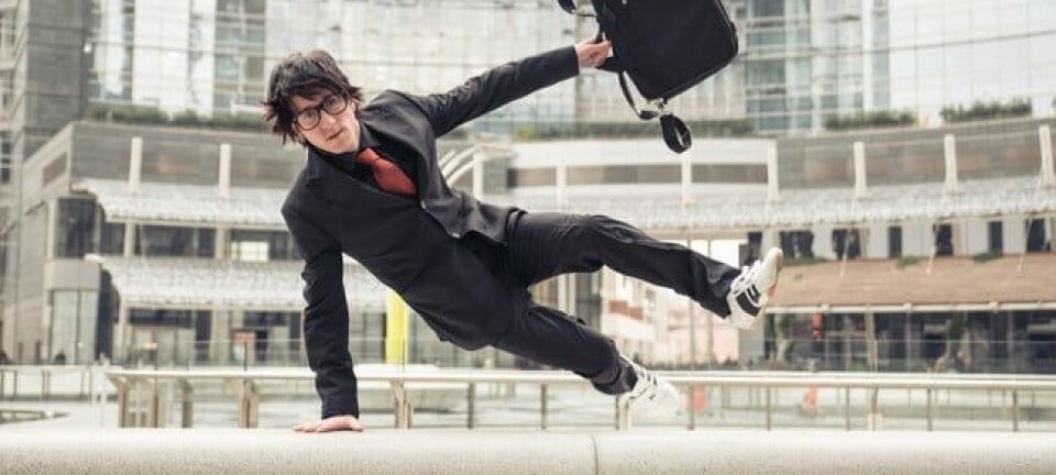 Business man with suitcase jumping over urban obstacles