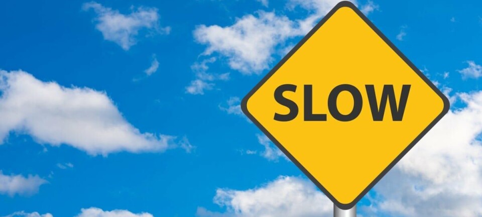 Slow Down road sign with cloudy background