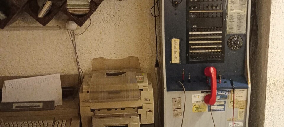 An old telephone switchboard next to a fax machine and typewriter