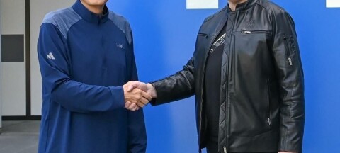Elon Musk and Intel CEO Lip Bu Tan shake hands outside what appears to be the chipmaker's Arizona fab