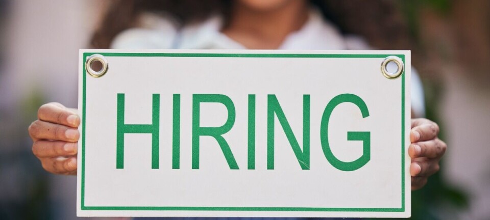 Person holding a sign that says hiring.